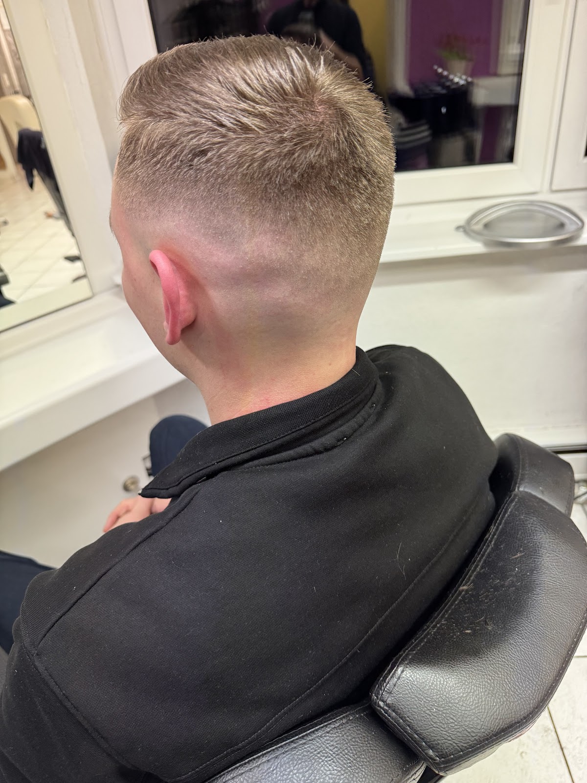 Heller Herrenhaarschnitt mit blondem Deckhaar und sauberem Skin Fade